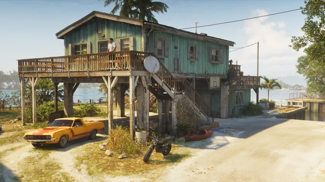 A stilted Keys safehouse with its vehicles parked underneath, a muscle-car ute, a dirt bike and a kayak. This is the Ultimate Edition safehouse vehicle set, and a good look at how the Keys actually live.